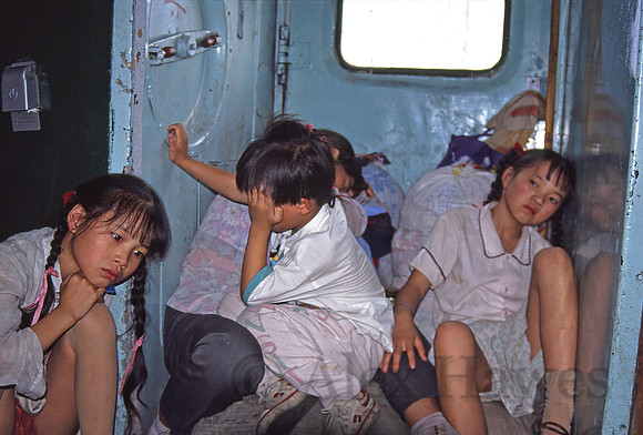 Family traveling train between cars, heading to Turpan, China